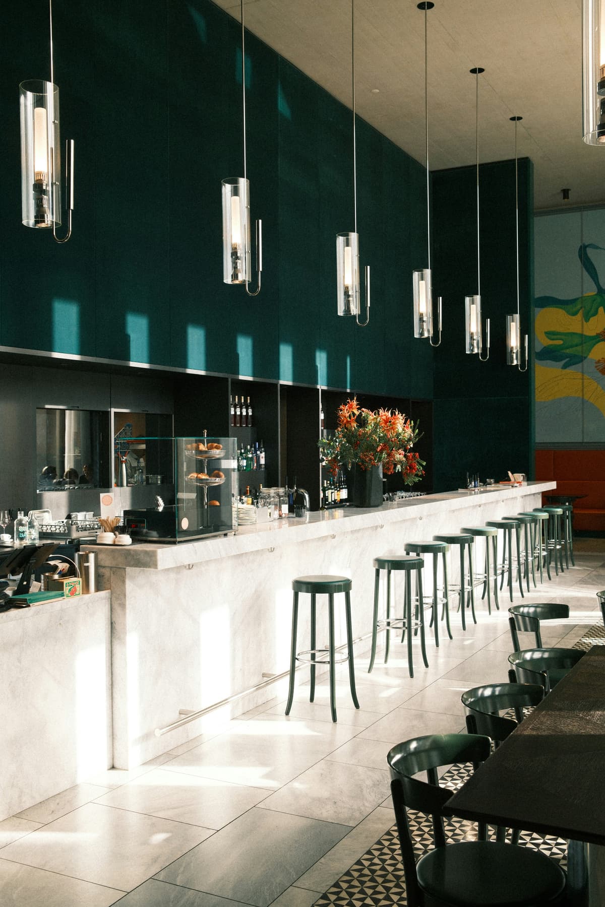Bar and café interior with deep green painted walls and a marble counter